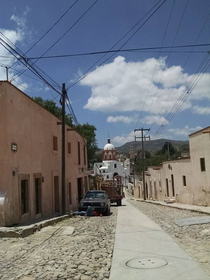 Calle empedrada de Mineral de Pozos con la cúpula de su parroquia al fondo